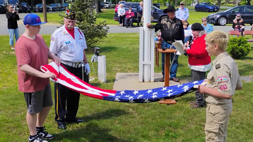 Benjamin Streeter (left) and Bayard Hard fold the American flag – with Chaplain Peter Newman looking on – as Bobbi Newman reads “The Meaning Behind the 13 Folds of Old Glory.”