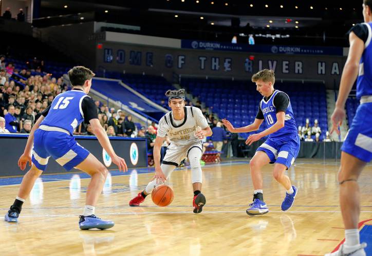 Pioneer’s Alex McClelland (15) dribbles between Hopedale defenders Keigan Murphy (15) and JJ Douglas (10) in the second quarter of the MIAA Div. 5 state championship Saturday at the Tsongas Center in Lowell. 