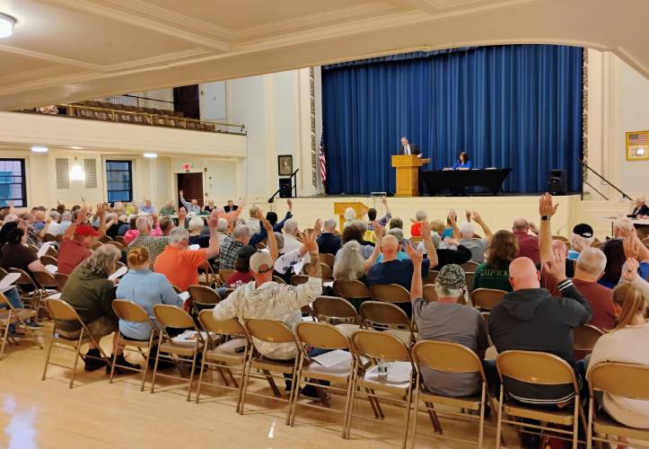 Athol voters raise their hands to approve one of 49 articles included on the warrant for The Annual Town Meeting.