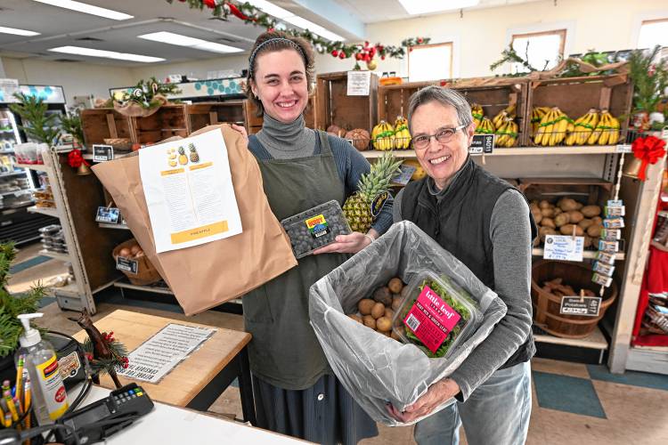 Quabbin Harvest team leader Camille Bedaw and treasurer Cathy Stanton with a food share at the Orange food coop.