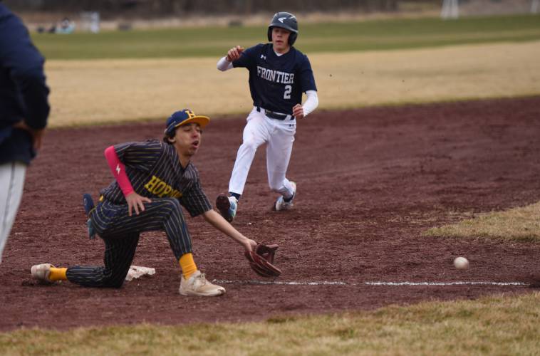 Hopkins Academy’s Nate Rickles, front, tries to knock down an errant throw from the Golden Hawks’ catcher as Frontier’s Carter Miller (2) slides into third base on Wednesday afternoon in Hadley.