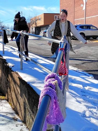 Dana Mallet (front) and Lindsay Franklin decorate the railing at the bus stop across from the Athol Area YMCA for the annual ‘scarf bombing.’ Now in its 10th year, volunteers arranged more than 400 donated scarves, hats and gloves.
