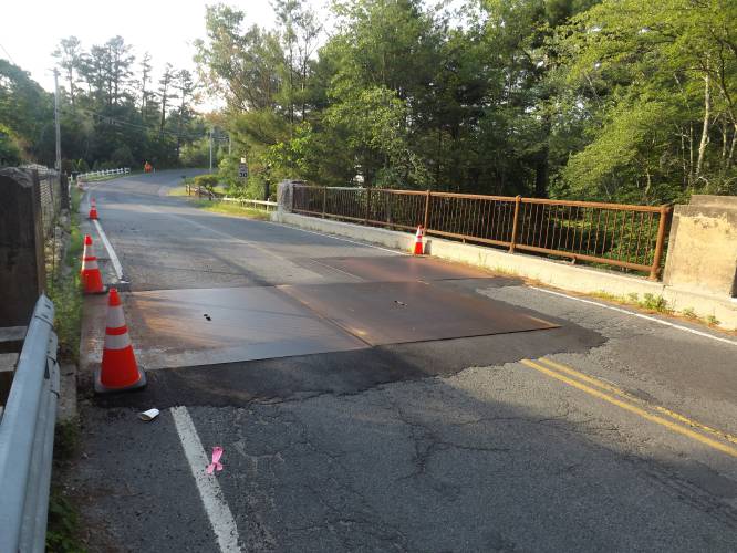 Steel plates cover gaping holes in the deck of the Pinedale Avenue bridge, as seen in July 2019. Replacement of the entire span is set to resume next week. 