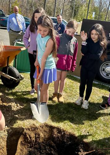 Students from Athol Community Elementary School shovel dirt as they plant an October Glory red maple for the town’s Arbor Day event on Wednesday.