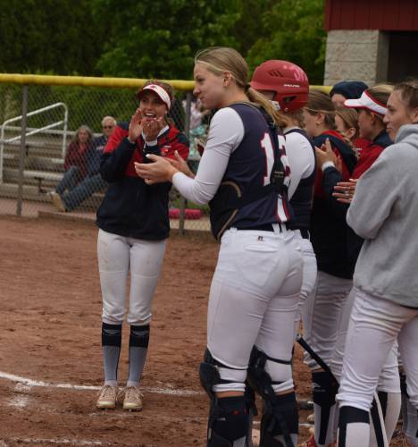 Frontier’s Olivia Machon, left, and the rest of the Redhawk team awaits Raine Wonsey after she hit a solo home run during the Redhawks’ game with South Hadley on Monday afternoon in South Deerfield.