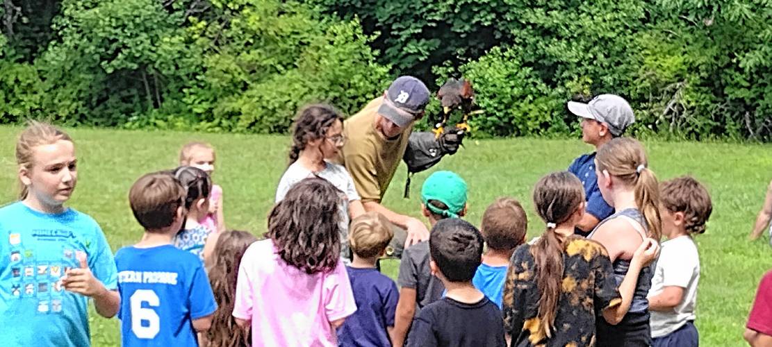 Children get a close-up look at Mahood, a Harris's hawk, perched on the arm of Henry Wallace.