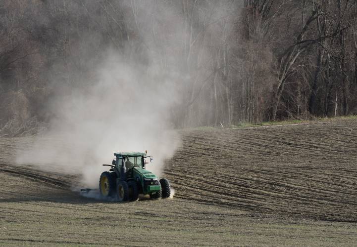 A tractor kicks up a cloud of dust as a farmer turns over this dry field in Gill in November.