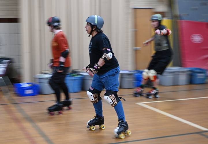 Members of the Pioneer Valley Roller Derby warm up skating around the perimeter of the gymnasium at Franklin Countys YMCA in Greenfield. 
