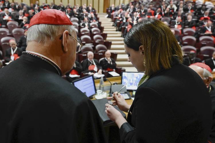 A Vatican employee annulls the papal seal at the Vatican on Tuesday.