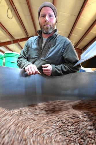 Brendan Walsh, head roaster and coffee buyer at Dean’s Beans Organic Coffee Co. in Orange, with beans just out of the roaster.