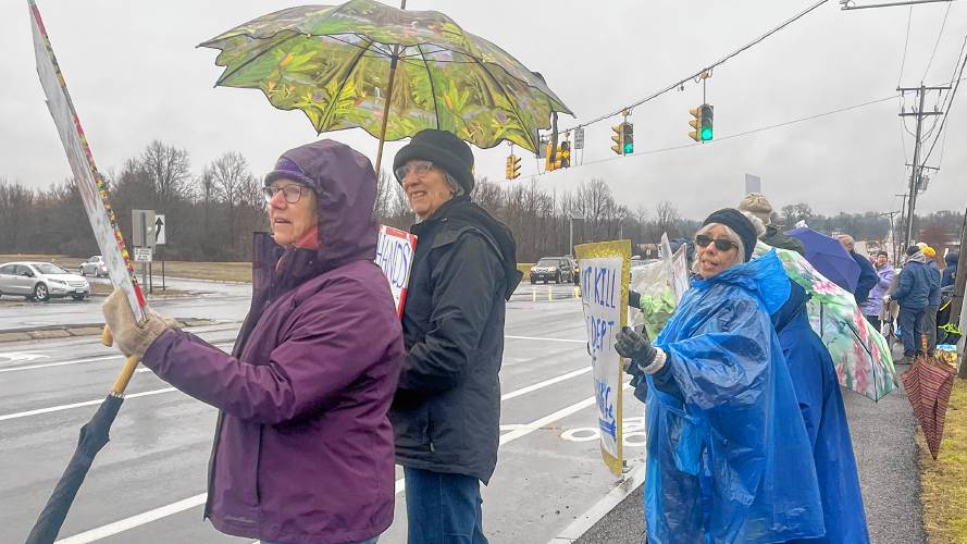 From the left, Nancy Jessup and Betsy McNamara stand with protest organizer Marta Lev to inform passing cars about the recent proibationary firings and office lease termination at the Fish and Wildlife Services. 
