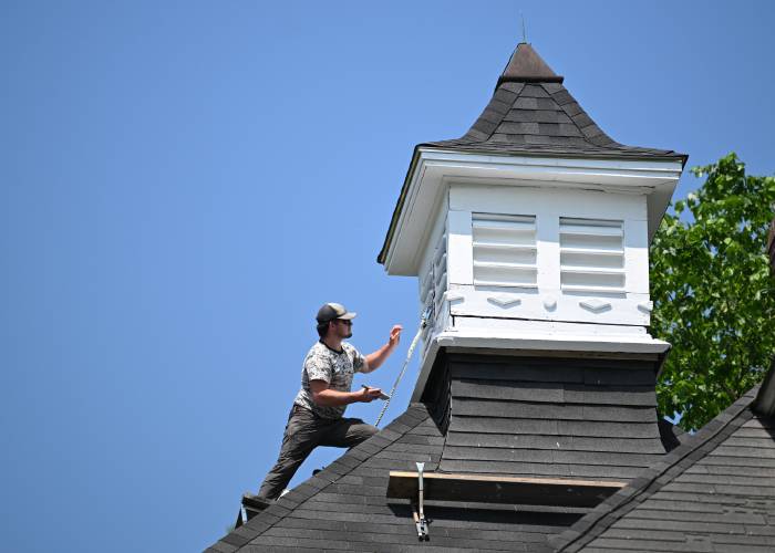 Chris Waslaske of C.W. Construction out of Athol paints a cupola on a house in Orange. Chris Waslaske of C.W. Construction out of Athol paints a cupola on a house in Orange.
