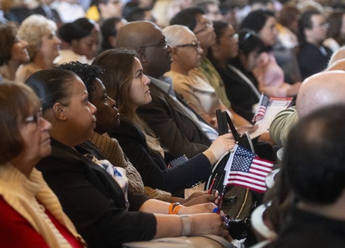 New American citizens listen to speakers during a naturalization ceremony at Bowker Auditorium, Tuesday, in Amherst.