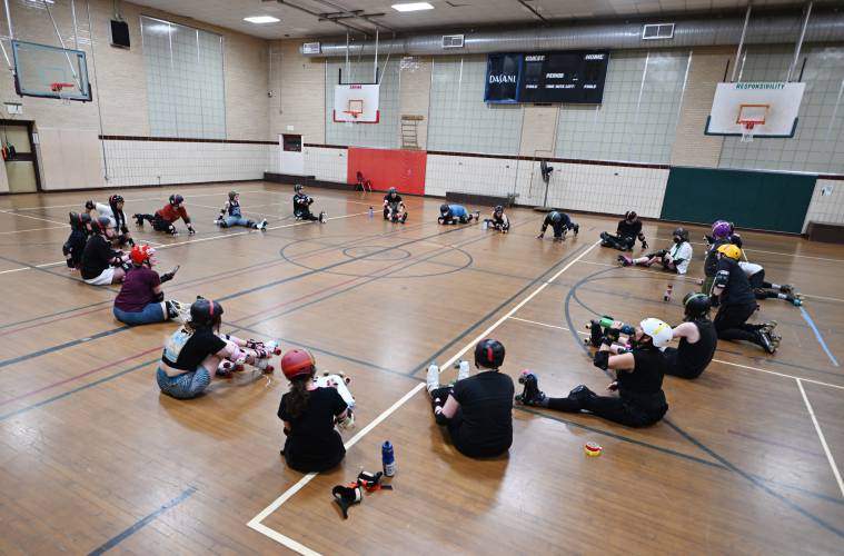 Participants of the Pioneer Valley Roller Derby stretch at Franklin Countys YMCA in Greenfield. 