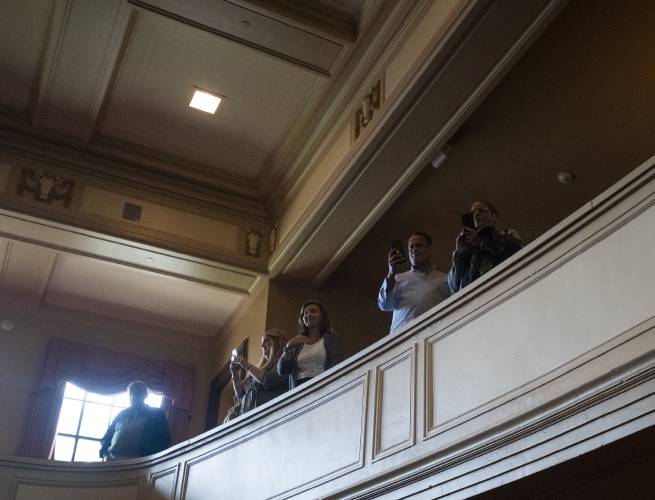 Friends and family members film as new U.S. citizens walk out after a naturalization ceremony at Bowker Auditorium, Tuesday, in Amherst.