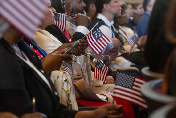 New American citizens listen to speakers during a naturalization ceremony at Bowker Auditorium, Tuesday, in Amherst.