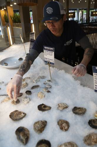 Yushan Zheng, a shucker at the Amherst Oyster Bar, sets up the oyster display by the bar at the restaurant. Amherst Oyster Bar is participating in Amherst Restaurant Week, June 8-12.