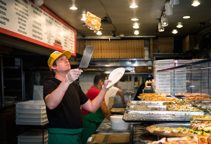 Tiberius Downs tosses a slice of pizza before plating it for a customer at Antonio’s Pizza in Amherst. The popular pizza spot is participating in Amherst Restaurant Week, June 8-12.