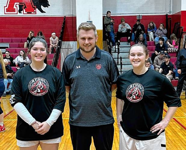 Athol High School seniors Anna Duquette (left) stands with Jenna Bonenfant and coach Conor Morrisey. The two players helped organize next Monday’s “Hoops 4 Hunger” game for the Athol High School Food Pantry.