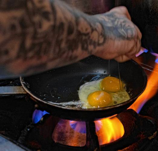 Marc Spivey, a line cook at Jake’s in Northampton, cooks eggs on a busy Monday morning. The restaurant uses 3,000 eggs a week on average.