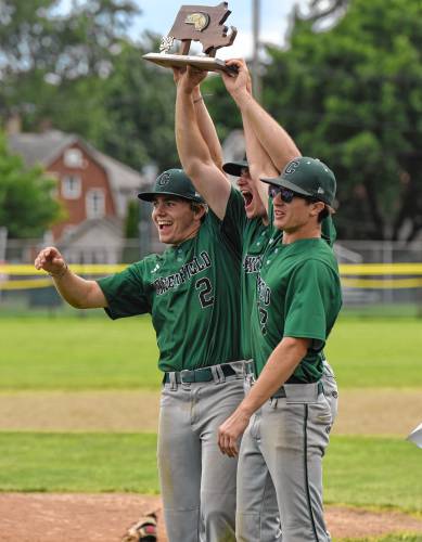 Greenfield’s John Marchefka (2), Michael Pierce and Deven Dubie hold up the Final Four trophy after the team’s 7-3 win over Bourne in the MIAA Division 5 quarterfinal round on Saturday at Vets Field in Greenfield.