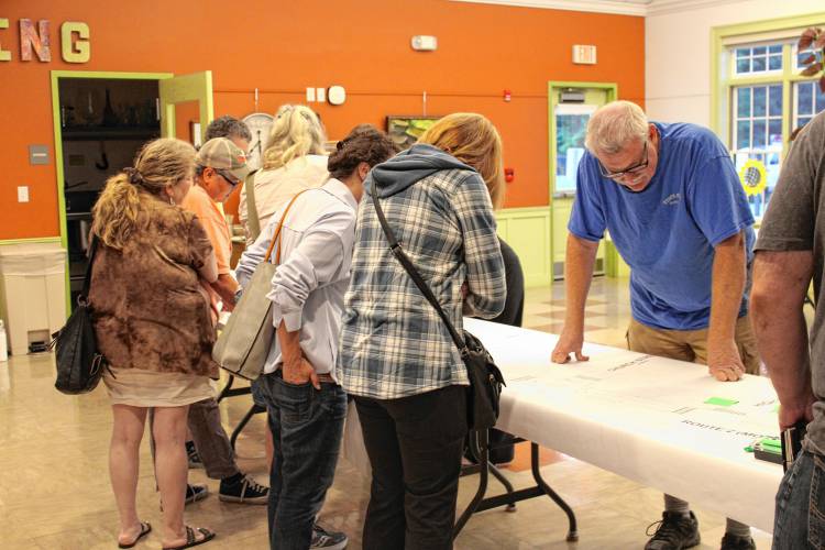 Residents examine the paper layout of the new proposed Route 2 redesigns by Green International Affiliates, Inc. in Erving on Wednesday night.