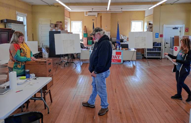 Phillipston Town Clerk Karin Foley checks in voters on their way to deposit their completed ballots in.
