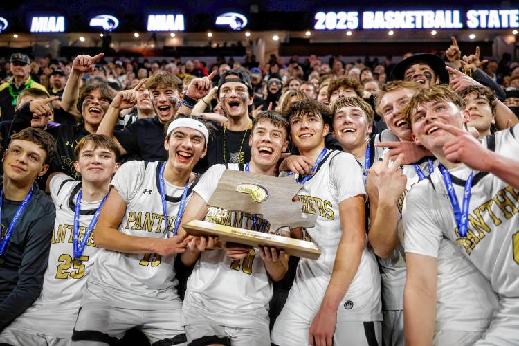 The Pioneer boys basketball team celebrates with the fan section after beating Hopedale 49-28 to win the MIAA Division 5 state championship Saturday at the Tsongas Center in Lowell.
