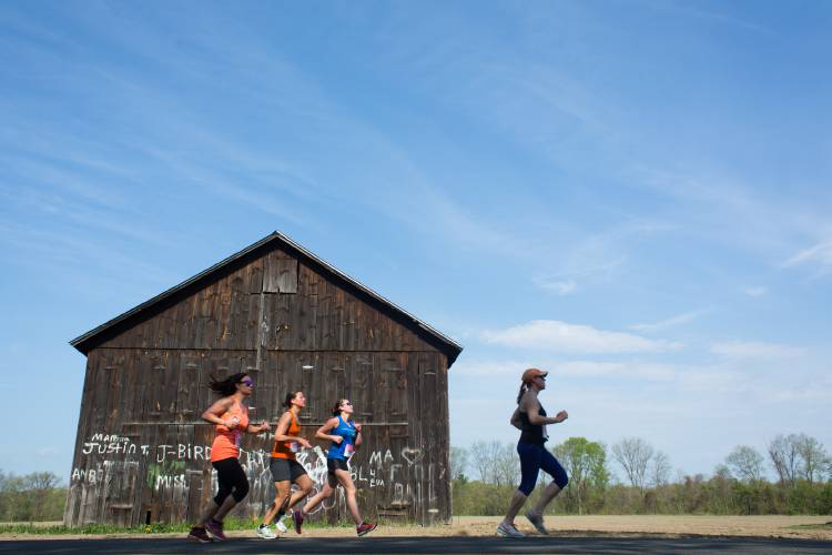 Participants in a past Mother's Day Half Marathon run down River Road in Hatfield.