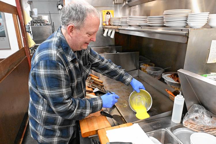 Dan Devine, owner of Brad’s Place in Greenfield, cooks an omelet for a customer.