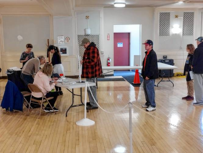Poll workers check in voters in Athol on Nov. 5 at Town Hall. Both floors of the Town Hall were set up for voters, due to the expected high turnout.