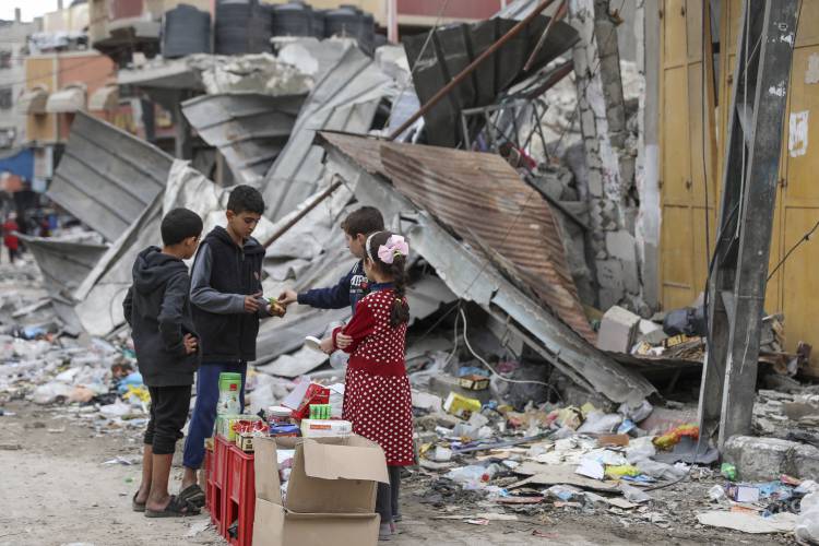 Palestinian children sell sweets in front of the rubble of a destroyed building in Jebaliya refugee camp in the Gaza Strip on Nov. 28. Palestinian children sell sweets in front of the rubble of a destroyed building in Jebaliya refugee camp in the Gaza Strip on Nov. 28.