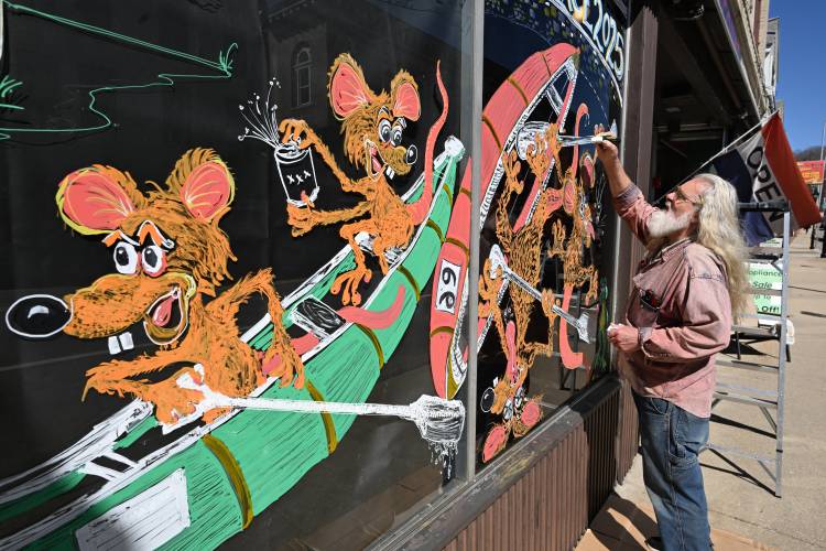 Leominster resident Steve Leger creates a mural on the window of the Mass Discount Center on Main Street in Athol on Wednesday to promote the 60th annual River Rat Race coming up on Saturday. Leominster resident Steve Leger creates a mural on the window of the Mass Discount Center on Main Street in Athol on Wednesday to promote the 60th annual River Rat Race coming up on Saturday.
