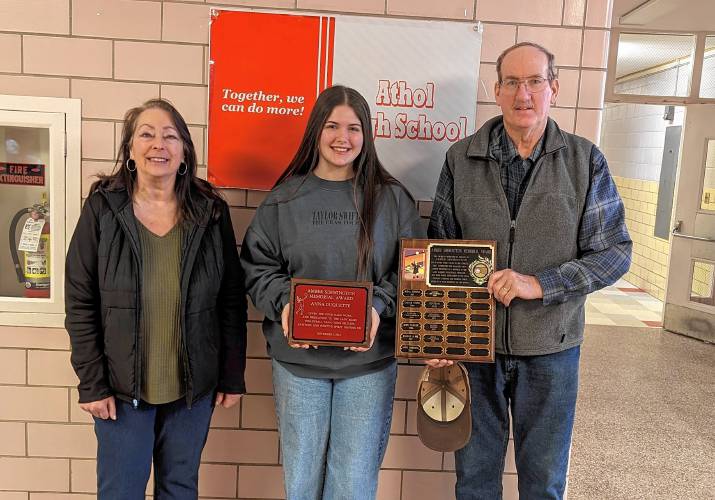 The Athol Girls Volleyball program recognized Anna Duquette, who was recently awarded the Amber Simmington Memorial Award. This award is presented each year to a chosen student who exemplifies Amber's character and spirit. In her senior year, Amber received the Award of Excellence for her exemplary display of sportsmanship, ethics, and integrity; after which the Amber Award is patterned. This award was initiated by Amber's coach, Bernie Merron, and is supported by her parents. Pictured here are (L-R) Deb Simmington, Anna Duquette and Dan Simmington.