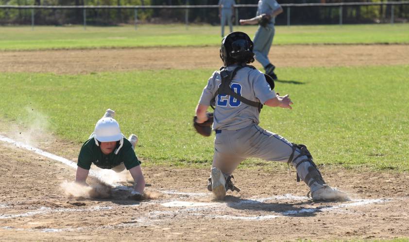 Greenfield’s Chase Zraunig, left, attempts a slide to beat Granby catcher Gavin Kennedy, right, to the place during the Green Wave’s 10-0 win over the Rams on Monday afternoon in Granby.