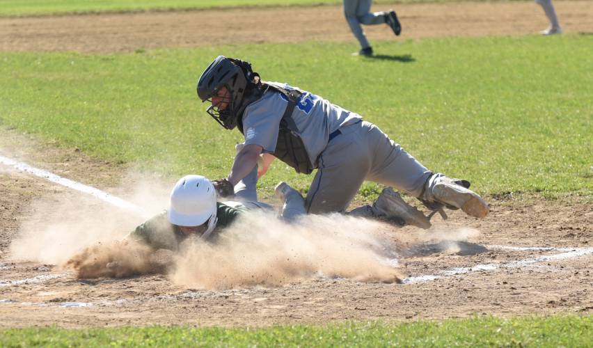 Greenfield’s Chase Zraunig slides safely into home, beating Granby catcher Gavin Kennedy to the plate during the Green Wave’s 10-0 win over the Rams on Monday afternoon in Granby.
