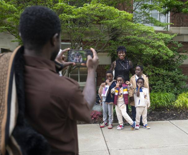 Doreen Acheampong, originally from Ghana, takes a photograph with her sons after a naturalization ceremony at Bowker Auditorium, Tuesday in Amherst.