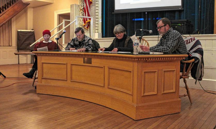 Left to right, Orange Selectboard member Jane Peirce, member Richard Sheridan, Clerk Pat Lussier and Vice Chair Andrew Smith sit at the front of the Ruth B. Smith Auditorium in Orange Town Hall during a Special Town Meeting on Thursday.