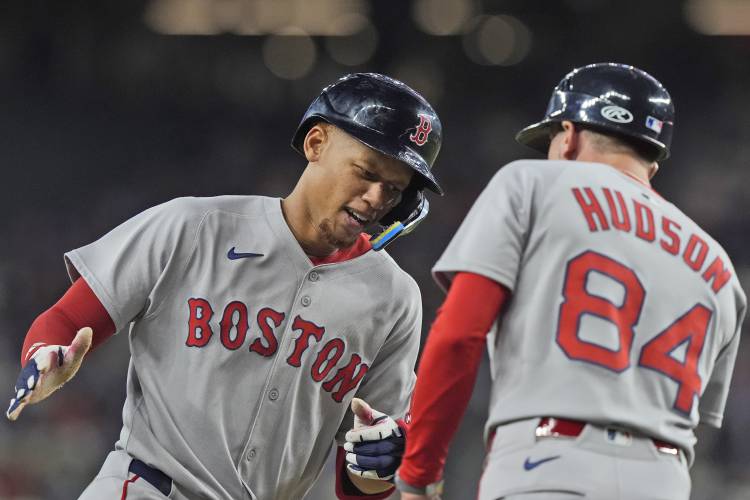 Boston Red Sox's Kristian Campbell, left, runs the bases past third base coach Kyle Hudson (84) after his home run during the fourth inning of a baseball game against the Texas Rangers, Saturday, March 29, 2025, in Arlington, Texas. (AP Photo/LM Otero)