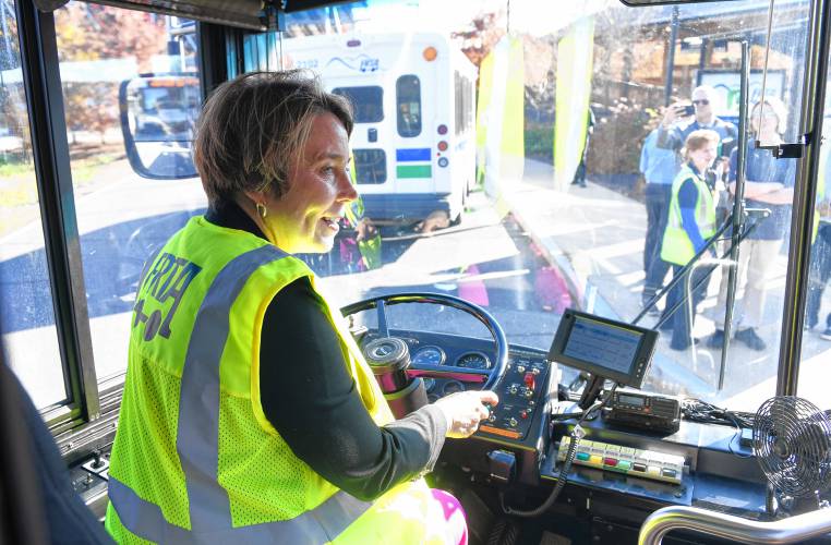 Massachusetts Gov. Maura Healey sits in the driver’s seat of a Franklin Regional Transit Authority (FRTA) bus for a photo op after announcing fare-free regional transit on Thursday.