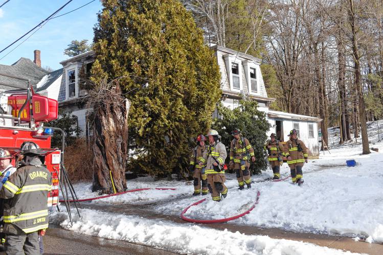 Fire fighters exit a two story gambrel style home that was the scene of a two alarm fire Wednesday morning on Mechanic Street in Orange. 