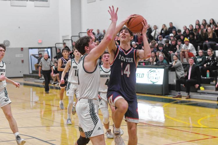 Frontier’s Owen Babb tries to shoot past Greenfield’s Jonathan Breor during Hampshire League South action at Nichols Gymnasium in Greenfield on Tuesday evening.