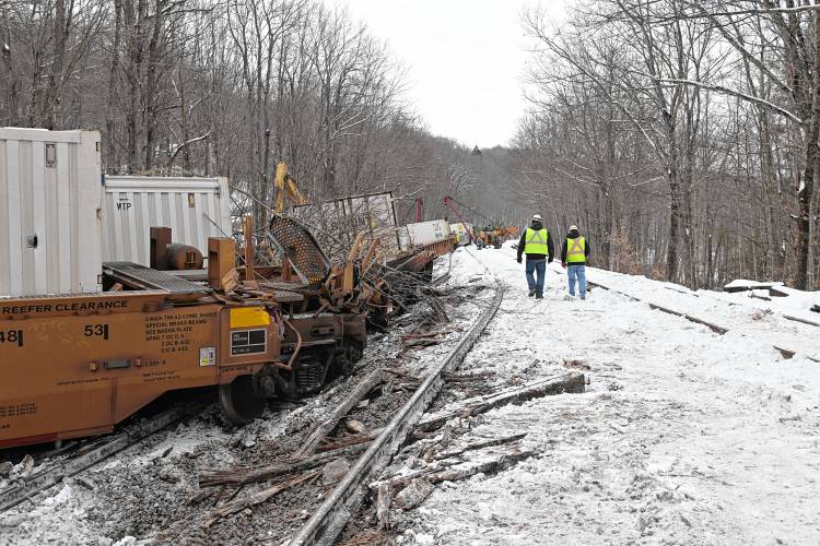 Workers begin the clean up of twisted rail road tracks and derailed freight cars off Farley Road in Wendell.