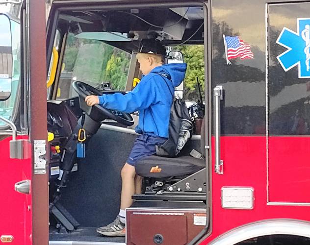 This youngster takes a turn at the steering wheel of one of Athol's fire trucks at the National Night Out event on Tuesday.