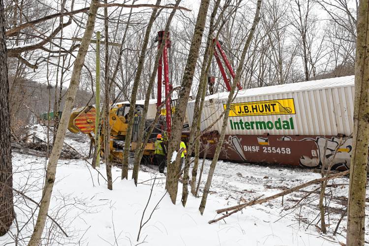 Workers begin to right derailed freight cars off Farley Road in Wendell on Wednesday.