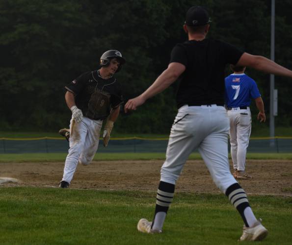 Pioneer’s Ethan Quinn rounds third under the direction of head coach Kevin Luippold during the Panthers’ extra innings victory over Georgetown in the MIAA Division 5 Round of 16 on Thursday night in Northfield.