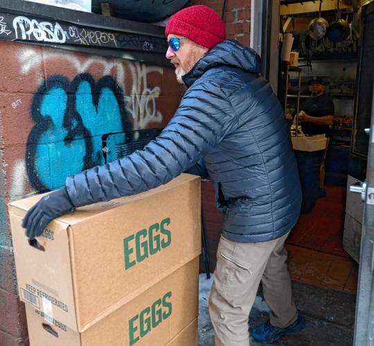 Chris Ware, owner of Jake’s in Northampton, unloads cases of eggs he got from Restaurant Depot in Chicopee on Tuesday morning. 