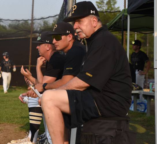 Pioneer’s coaches sit on buckets and watch their team during the Panthers’ extra innings victory over Georgetown in the MIAA Division 5 Round of 16 on Thursday night in Northfield.