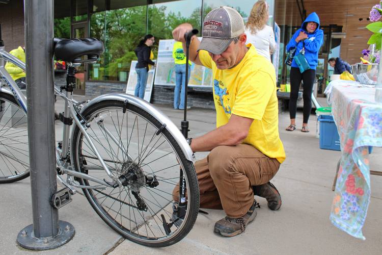 Franklin Regional Council of Governments Senior GIS Specialist Ryan Clary pumps up the tire of one of the agency's two bikes, which employees are able to take at any time.