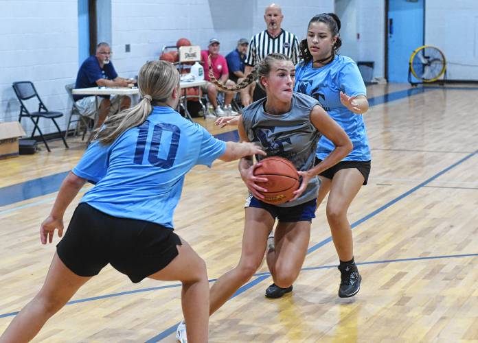 Mahar’s Nevaeh Scribner splits two Franklin Tech defenders during semifinal round action in the Franklin Tech Girls Summer Basketball League in Turners Falls on Tuesday night.
